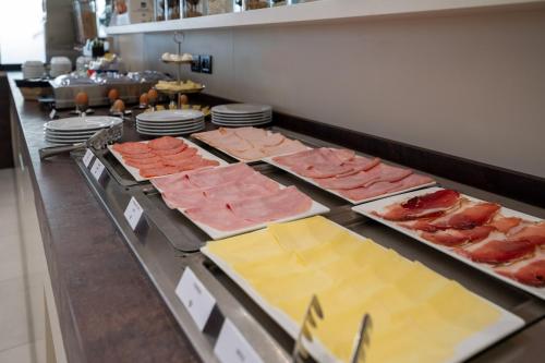 a buffet line with different types of meats and cheese at Ile Hotel in Peschiera del Garda