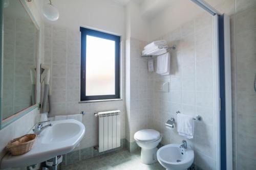a white bathroom with a sink and a toilet at Hotel Italia & Lombardi in Montefiascone