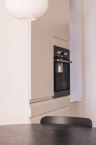 a kitchen with a black oven and a white wall at Perfect Apartments in Superb Location by Strøget, the Metro & Attractions in Copenhagen