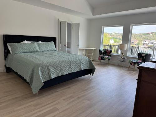 a white bedroom with a bed and a balcony at Por Que No Los Dos in Marble Falls