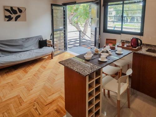 Ubicación y todo para tu desayuno في ميندوزا: مطبخ وغرفة معيشة مع أريكة وطاولة