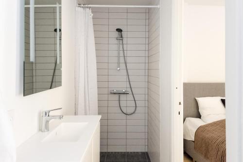 a white bathroom with a shower and a sink at Perfect Apartments in Superb Location by Strøget, the Metro & Attractions in Copenhagen