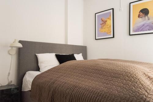a bedroom with a bed and two pictures on the wall at Perfect Apartments in Superb Location by Strøget, the Metro & Attractions in Copenhagen