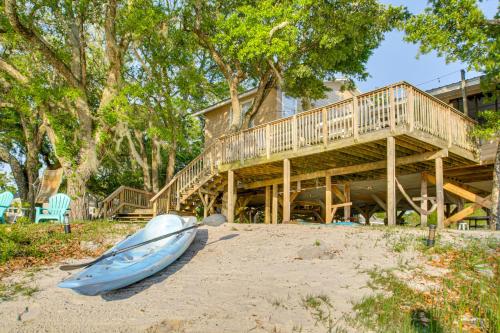 a boat on the beach in front of a house at Bayfront Haven Group Getaway in Milton! in Milton