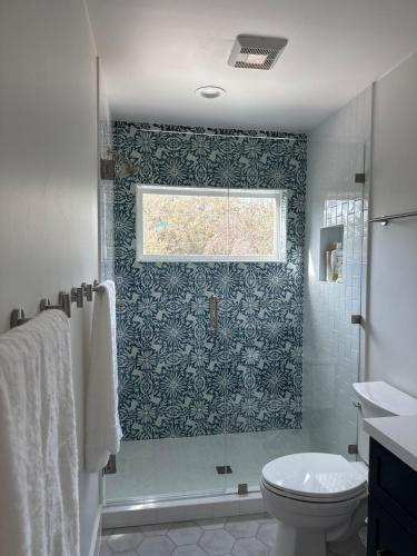 a bathroom with a shower and a toilet and a window at Por Que No Los Dos in Marble Falls