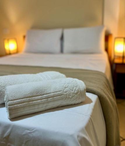 two white towels are sitting on a bed at Pousada Pangea Tropical in Arraial d'Ajuda