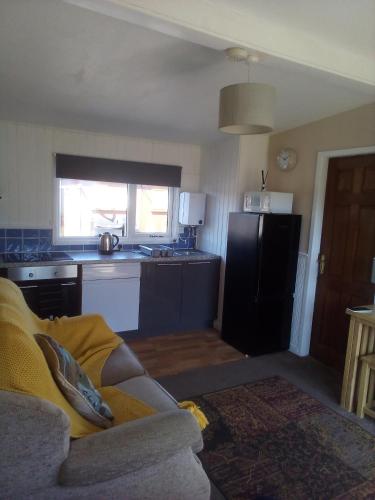 a living room with a couch and a kitchen at 2 bed seaside holiday Chalet in Mablethorpe