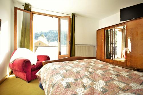 une chambre avec un lit, une chaise et une fenêtre dans l'établissement Plein-Sud - Parking & Vue Montagnes, à Barcelonnette