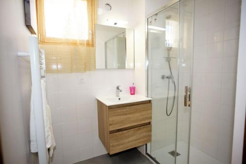 une salle de bain avec un lavabo et une douche dans l'établissement Plein-Sud - Parking & Vue Montagnes, à Barcelonnette