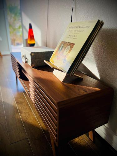 a table with a book and a suitcase on it at Newly Build House!Island Charm Balcony Vibes 3 Min to Beach in Galveston