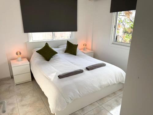 a bedroom with a white bed with two pillows on it at Casa Sea Breeze in Larnaca