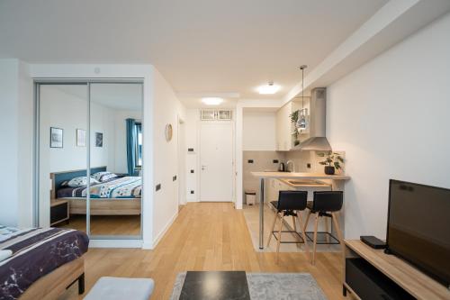 a bedroom with a bed and a kitchen with a table at Apartment Atrium- A blok in Novi Beograd
