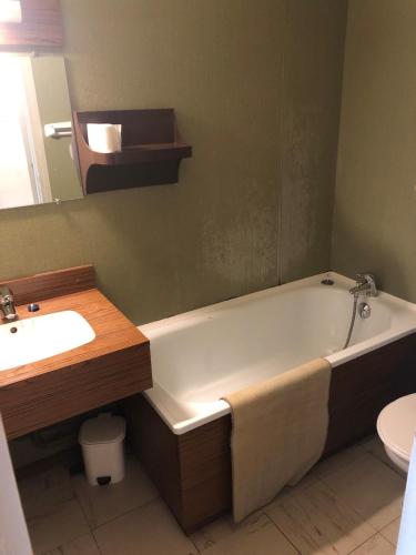 une salle de bain avec une baignoire et un lavabo dans l'établissement Studio au pied de la montagne, à Villard-de-Lans