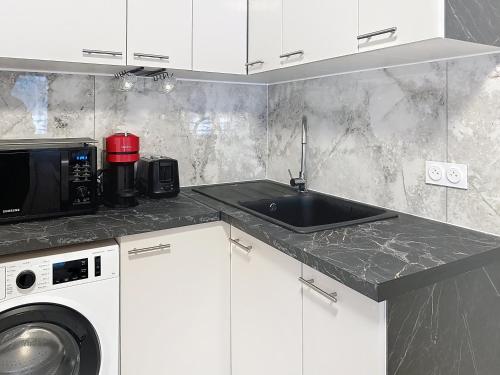 a kitchen with a sink and a microwave at Sky Apartment- Paris - Blanc Mesnil in Le Blanc-Mesnil