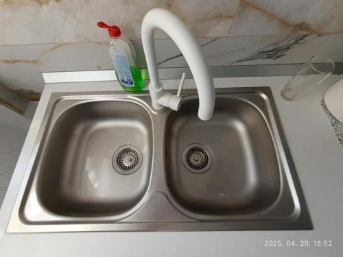 a kitchen sink with a faucet and a toothbrush at Apartament Flora in Văleni