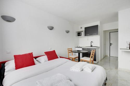 - 2 lits dans une chambre avec une table et une cuisine dans l'établissement Nice & Quiet Studio - Saint Denis, à Saint-Denis