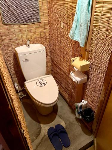 a bathroom with a toilet and a pair of slippers at Hostel Mundo in Kyoto