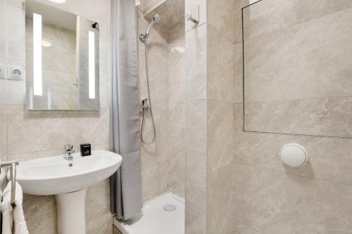 une salle de bain avec un lavabo blanc et une douche dans l'établissement Nice & Quiet Studio - Saint Denis, à Saint-Denis
