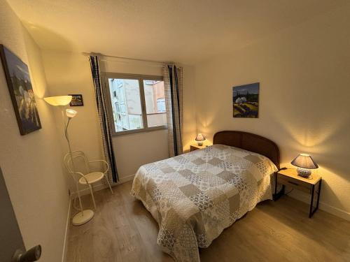 une chambre avec un lit et deux lampes et une fenêtre dans l'établissement Grand F2 40 m2 Centre Port, Loggia 5m2, Vue jardin, Belle Terrasse, Parking privé, au Cap d'Agde