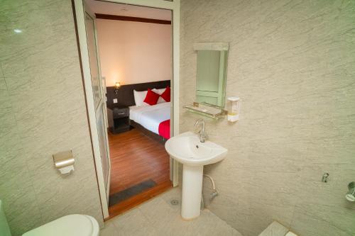 bagno con lavandino e letto con specchio di Hotel Juju a Pokhara