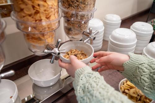 a woman is mixing food in a bowl at Ile Hotel in Peschiera del Garda