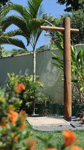 a wooden cross in a garden with a palm tree at Pousada Pangea Tropical in Arraial d'Ajuda