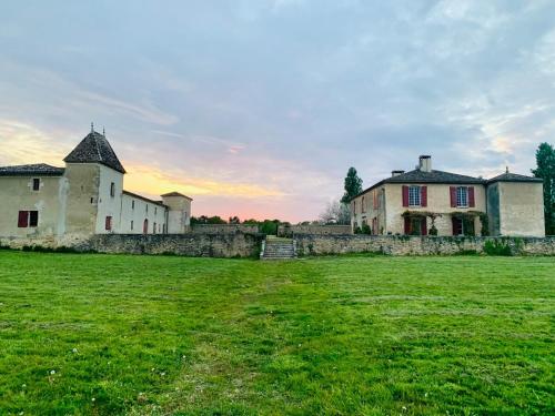 a group of buildings in a grassy field at Beaulieu Saint Come in Saint-Côme
