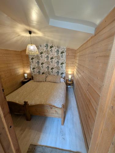 Cette petite chambre en bois comprend un lit. dans l'établissement Gîte au calme, nature et confort Creuse, à Soubrebost