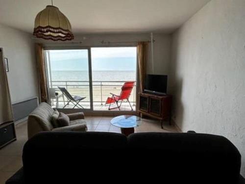 un salon avec un canapé et une vue sur l'océan dans l'établissement Studio vue incroyable, à Fort-Mahon-Plage