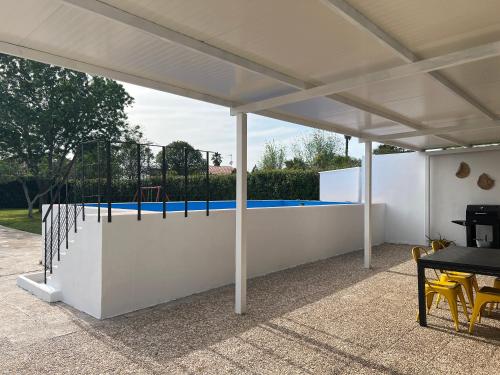 a white pavilion with a playground in the background at Casa Rural Macondo in Trujillanos