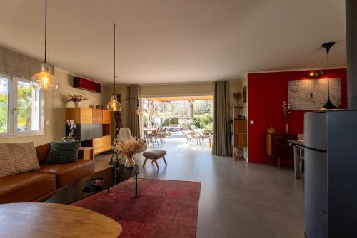 un salon avec un canapé marron et un mur rouge dans l'établissement Modern Villa with Hot Tub, 6P, à Roquebrune-sur Argens