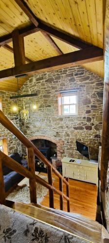 a stone fireplace in a room with a wooden ceiling at 2 Bed Sandstone Residence in Newport