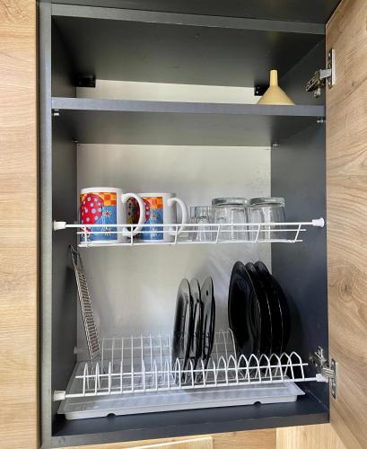 a shelf with mugs and utensils in a kitchen at Scandinavia Camping in Kamennaya Gora