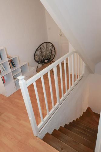 a staircase with white railings in a living room at Maison de charme au cœur d Elne in Elne