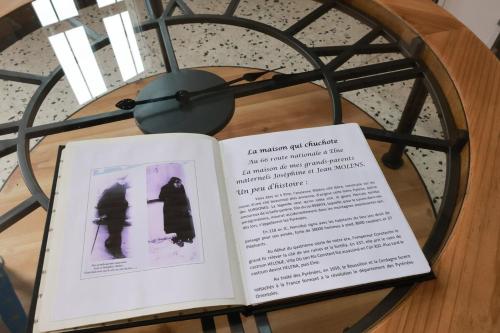 an open book on a table with a clock at Maison de charme au cœur d Elne in Elne
