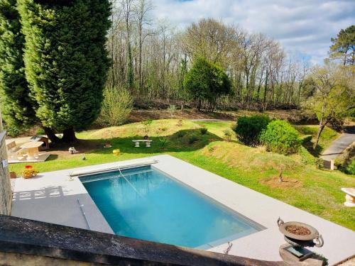 une vue aérienne d'une piscine dans un jardin dans l'établissement Villa La Canéda*Spacieuse*Piscine*Sarlat, à Sarlat-la-Canéda