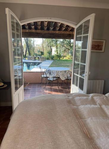 - une chambre avec un lit et une terrasse avec une table dans l'établissement Belle maison atypique, à Roquefort-les-Pins