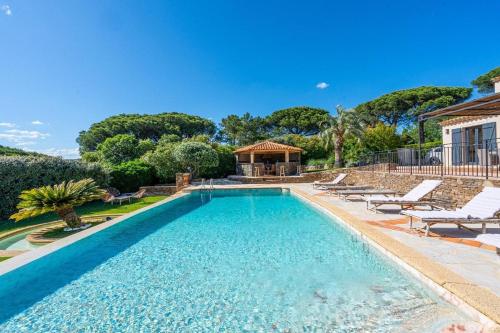 une piscine avec des chaises et une maison dans l'établissement Luxueuse villa vue vignes avec piscine et terrain de petanque, à Gassin
