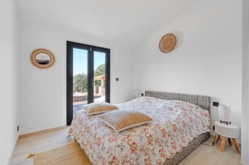 une chambre avec un lit et une grande fenêtre dans l'établissement Luxueuse villa vue vignes avec piscine et terrain de petanque, à Gassin