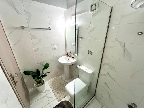 a white bathroom with a toilet and a sink at Blue dream in Nikiana