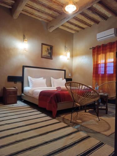 a bedroom with a bed and a chair at kasbah Dar Bahnini in Skoura