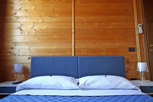 a bed with a blue headboard and two white pillows at Agriturismo BioCore - Collepietro - Mosciano S Angelo in Collepietra
