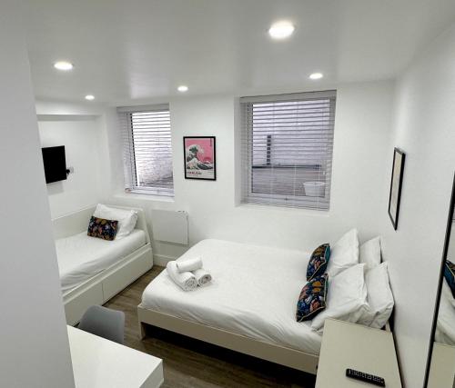 a white room with a bed and a couch at Charlotte Street Rooms by News Hotel in London