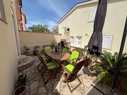 a patio with a table and chairs and an umbrella at Holiday house Matej in Vir