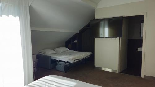 a small room with two beds and a refrigerator at Best Western Hotel Acadie Paris Nord Villepinte in Tremblay En France