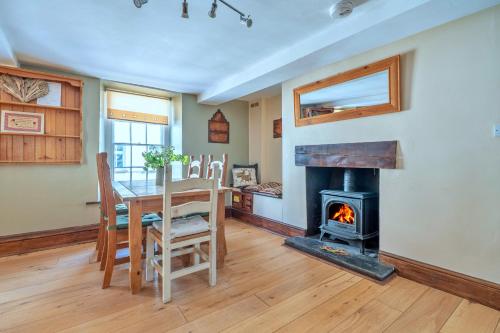 a dining room with a table and a fireplace at Finest Retreats - Yr Daflod in Brecon