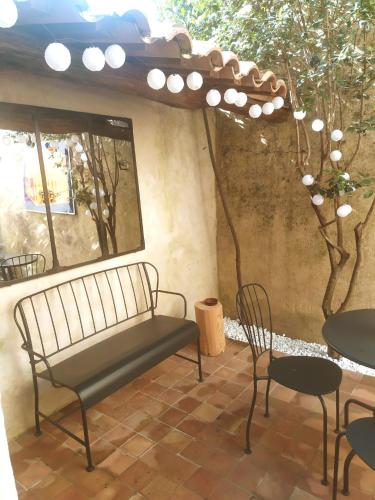 un banc installé sur une terrasse avec des tables et des chaises dans l'établissement La Casamia, maison avec cour privative, à 2 pas de la Place aux Herbes, à Uzès