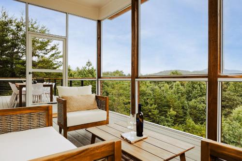 a room with a bed and a table and windows at Serenity Now 4br Fall Retreat Deck Fireplace in Young Harris