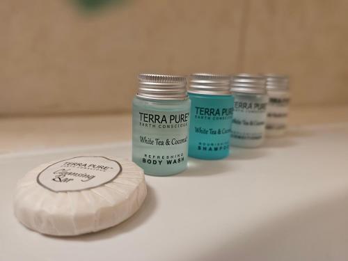 three jars of terrappe on a bathroom sink at Waterfront Tropical Themed 2 BR in Abu Dhabi