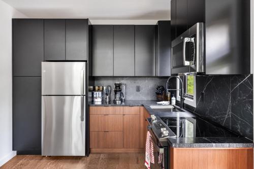a kitchen with black cabinets and a stainless steel refrigerator at Viking Hut Modern Forest Hideaway Fall Dogs in Young Harris